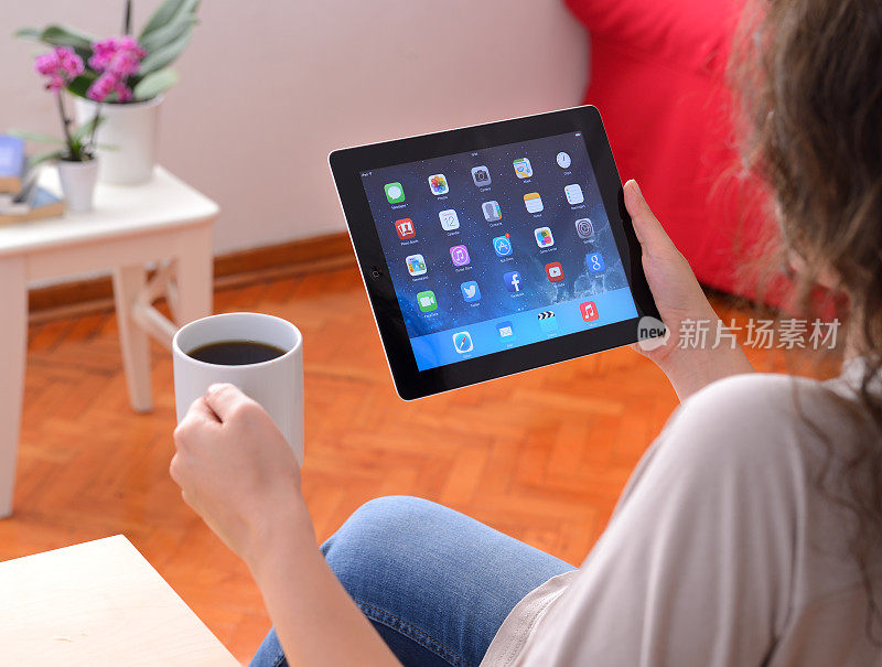 女用户使用苹果iPad，屏幕显示IOS 7
